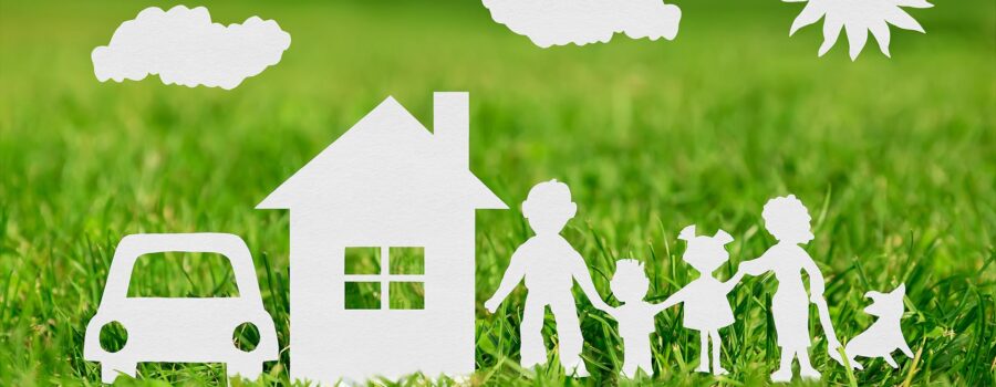 Paper cut of family with house and car on green grass representing your dream home